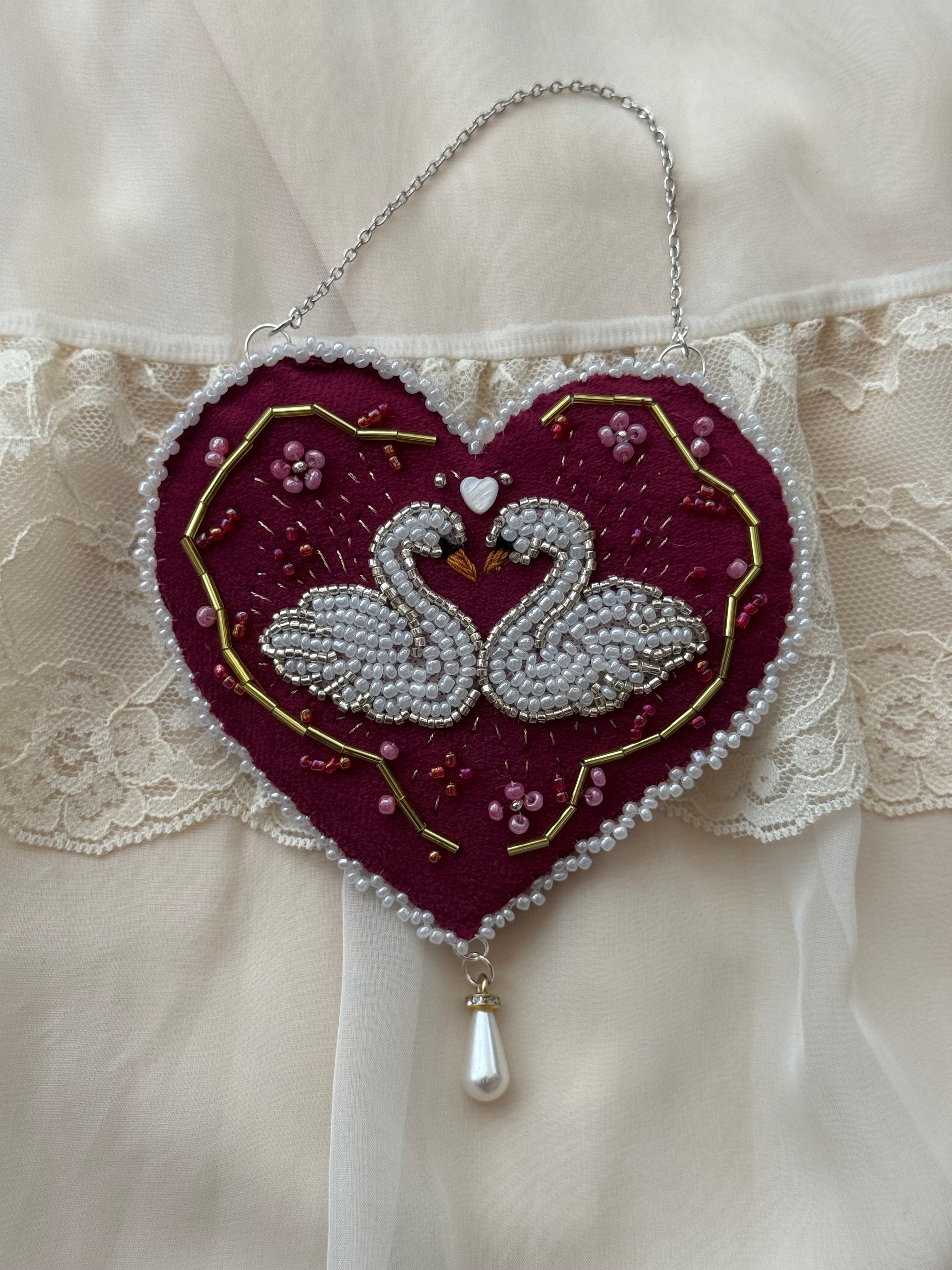 Decorative velvet wall hanging with twin swans and floral design on a lace background