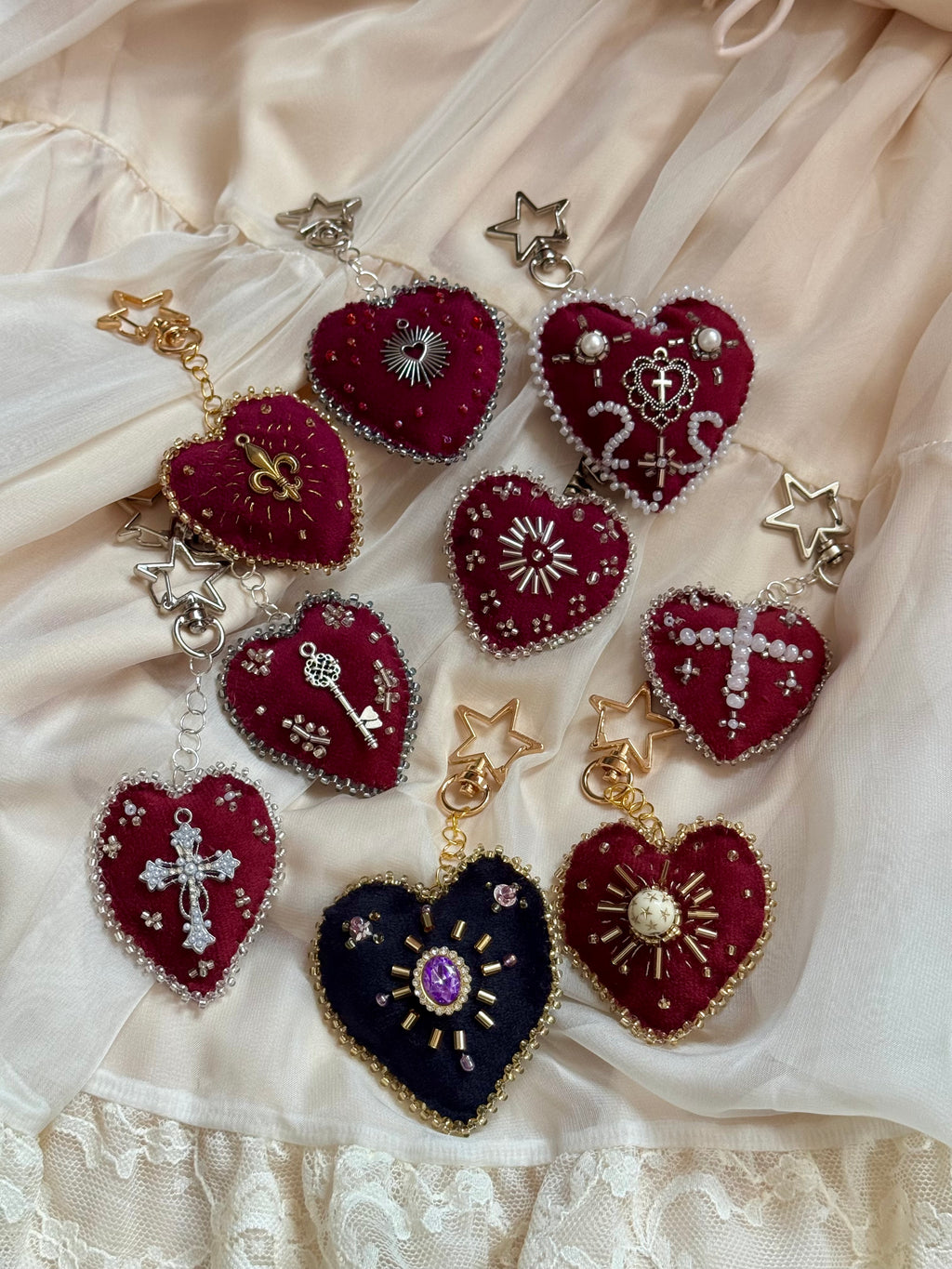 Heart-shaped jewelry pieces with various designs on a lace fabric background