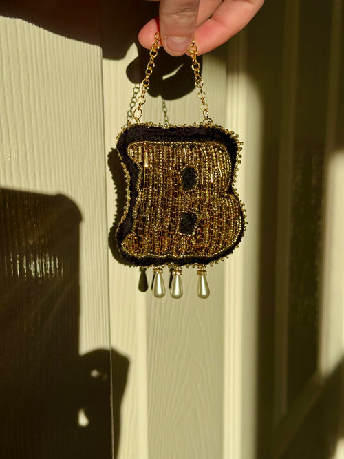 Girdle of Venus Boleyn in Triumph ornament held in hand, showing the 9cm size and hanging gold chain hardware.