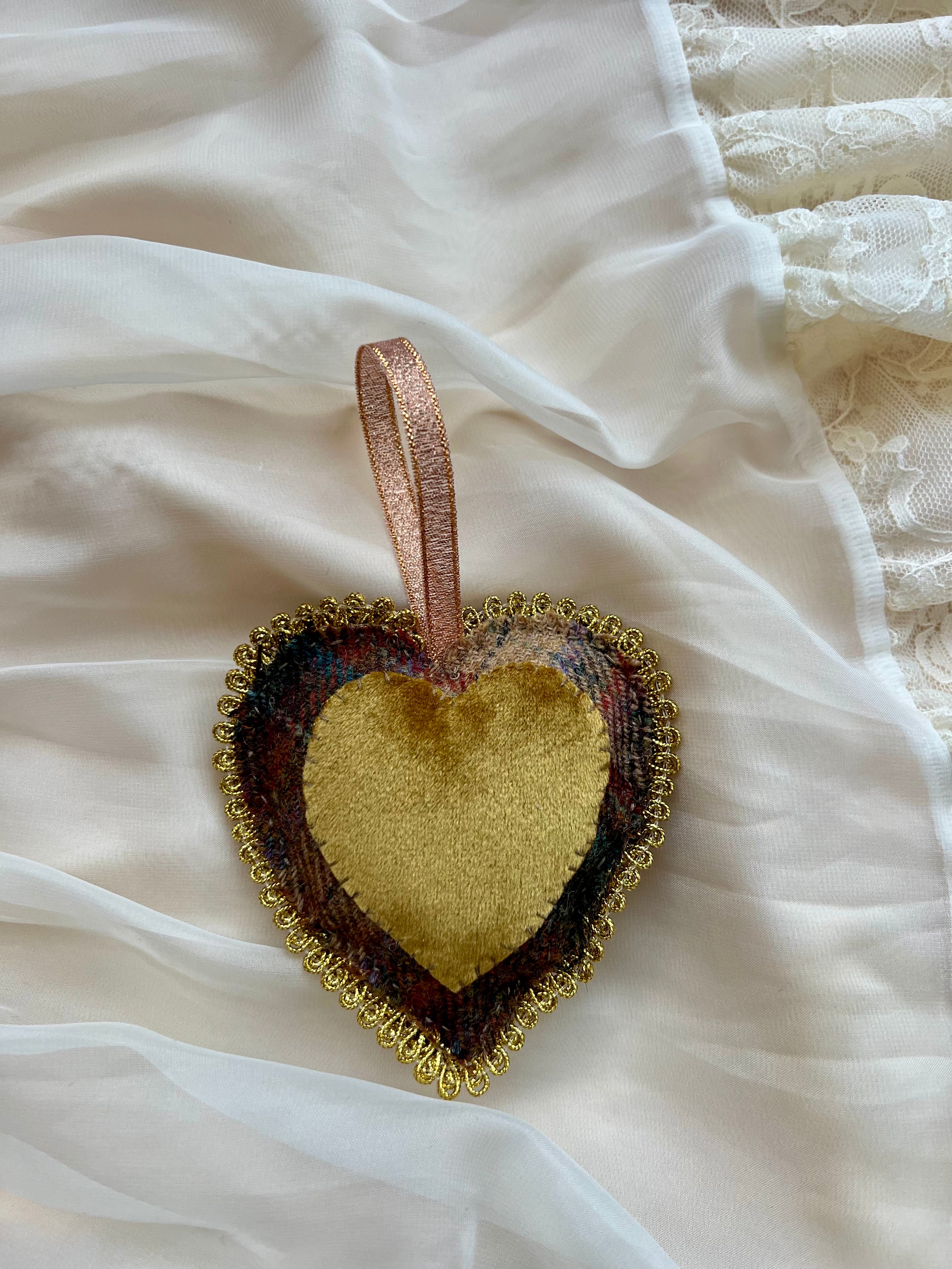 Heart-shaped decorative item with a ribbon on a white fabric background