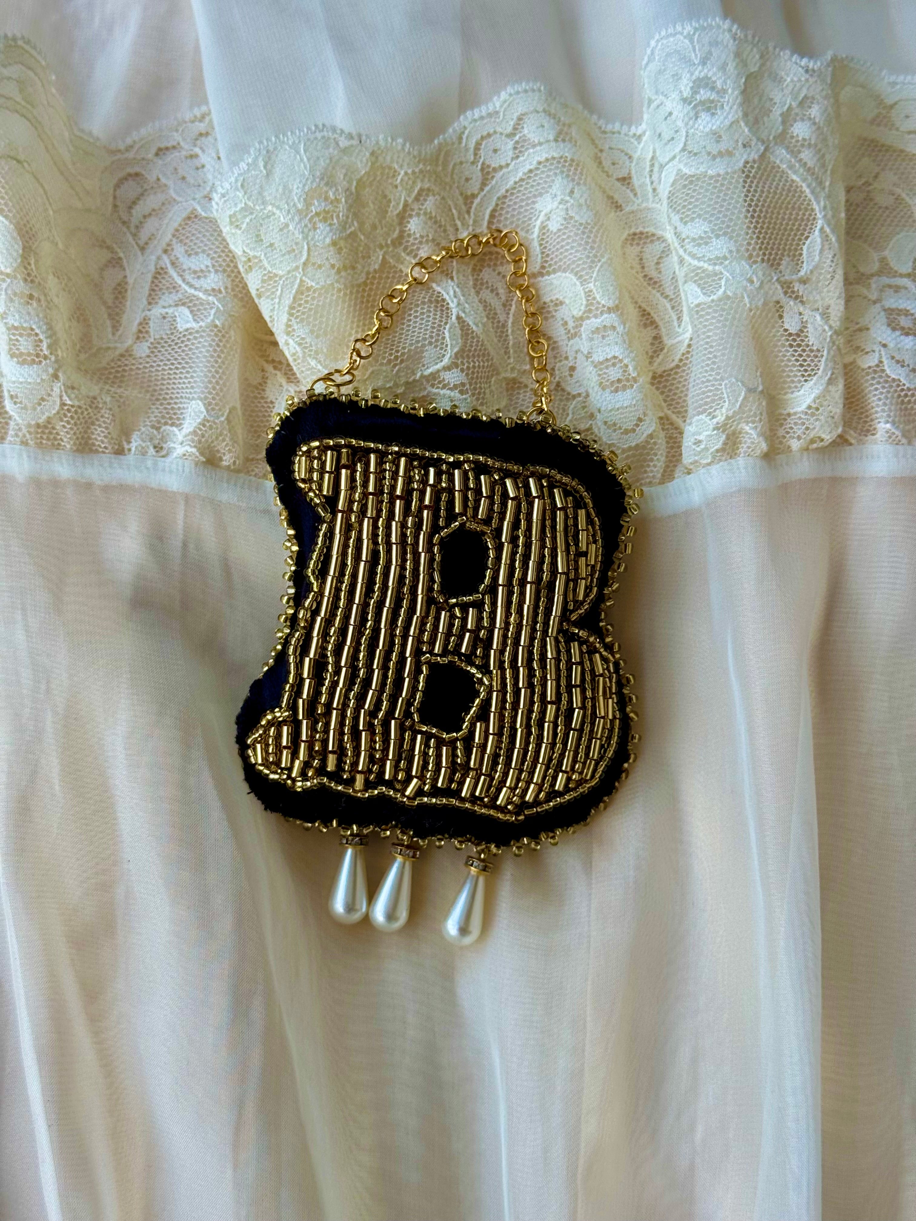 Detailed view of 14 hours of intricate gold beadwork and metallic gold-work on a handmade Tudor-inspired ornament.