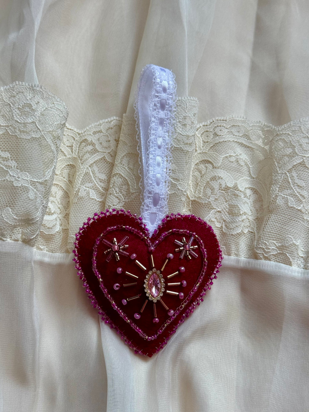 Decorative heart-shaped brooch with lace background