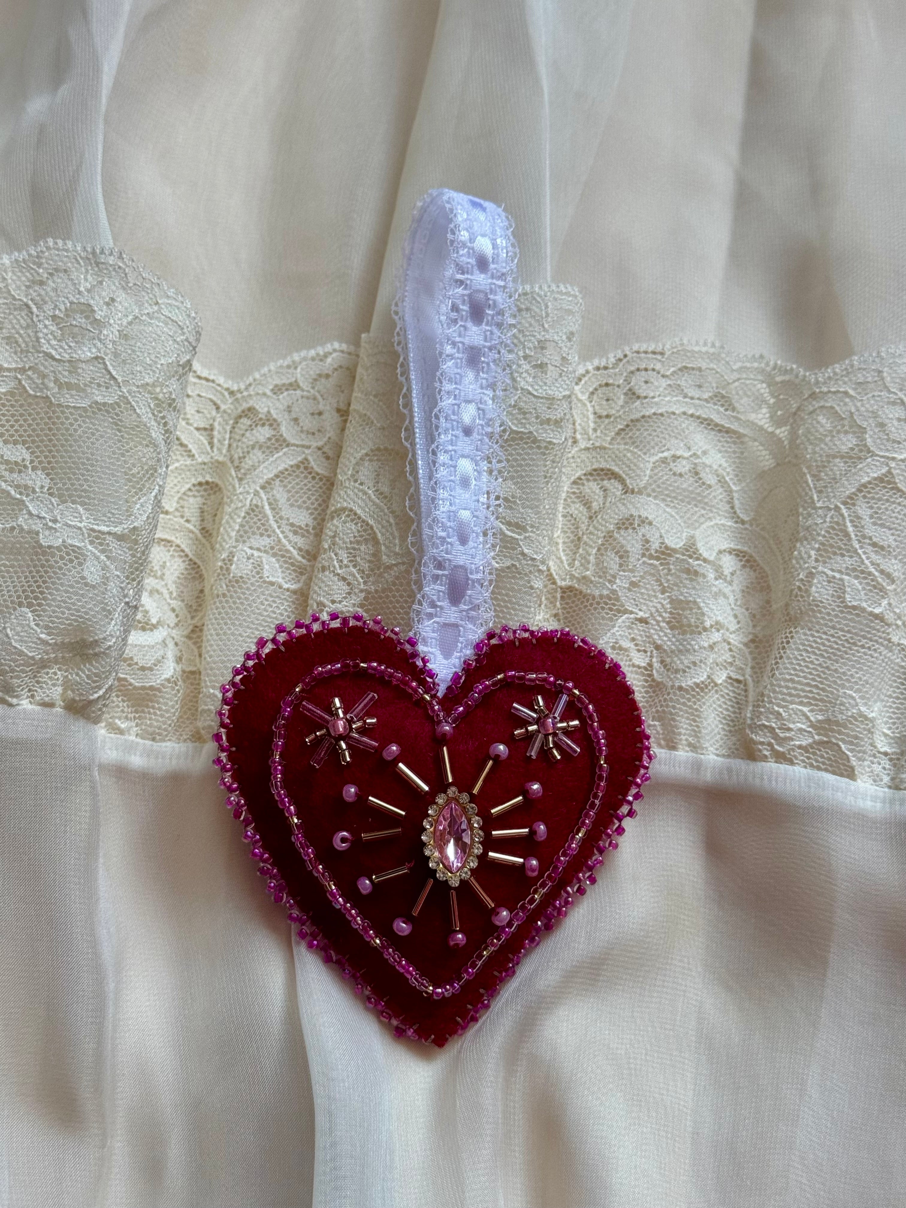 Decorative heart-shaped brooch with lace background