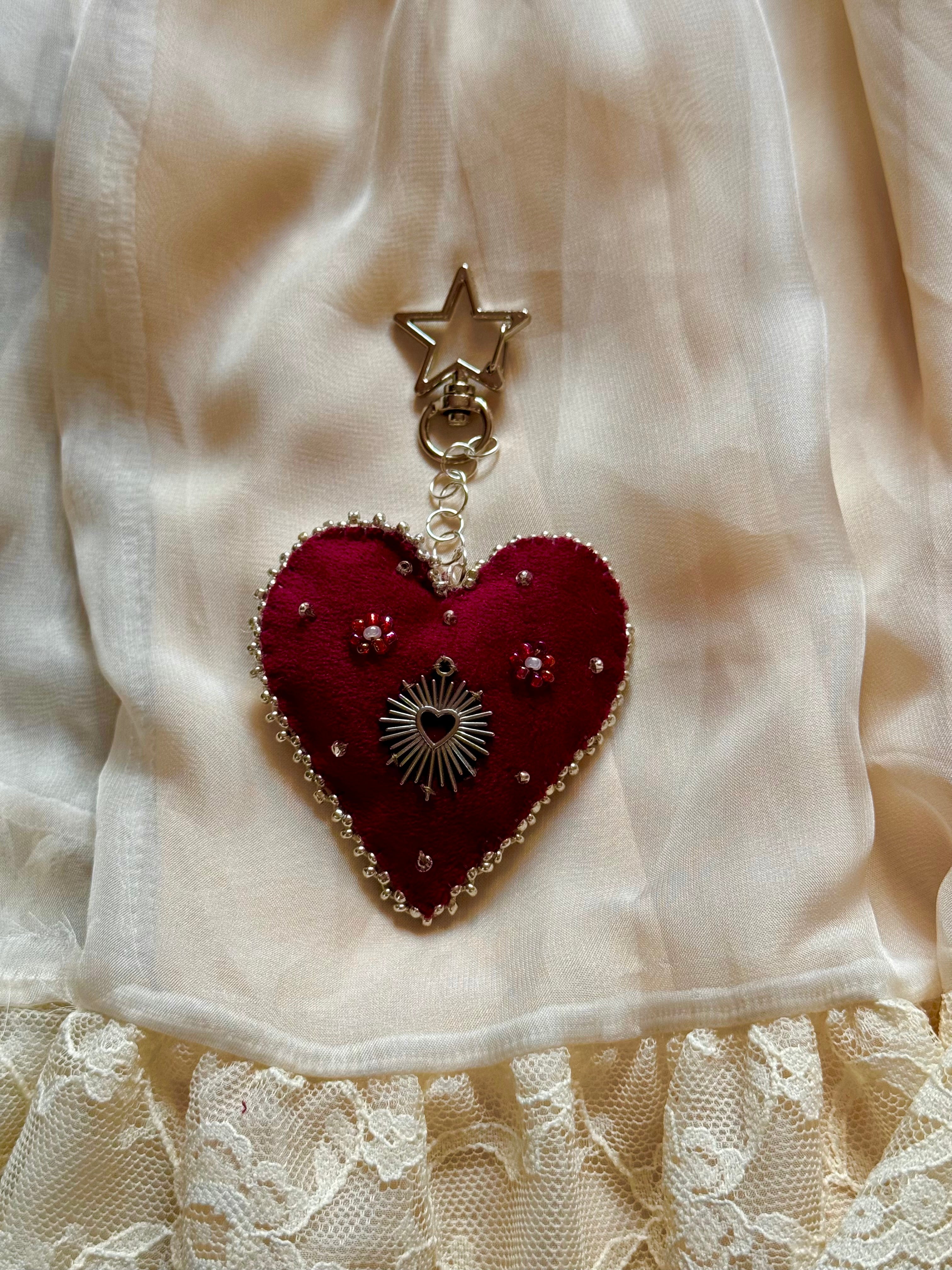 Heart-shaped pendant with star charm on a white fabric background