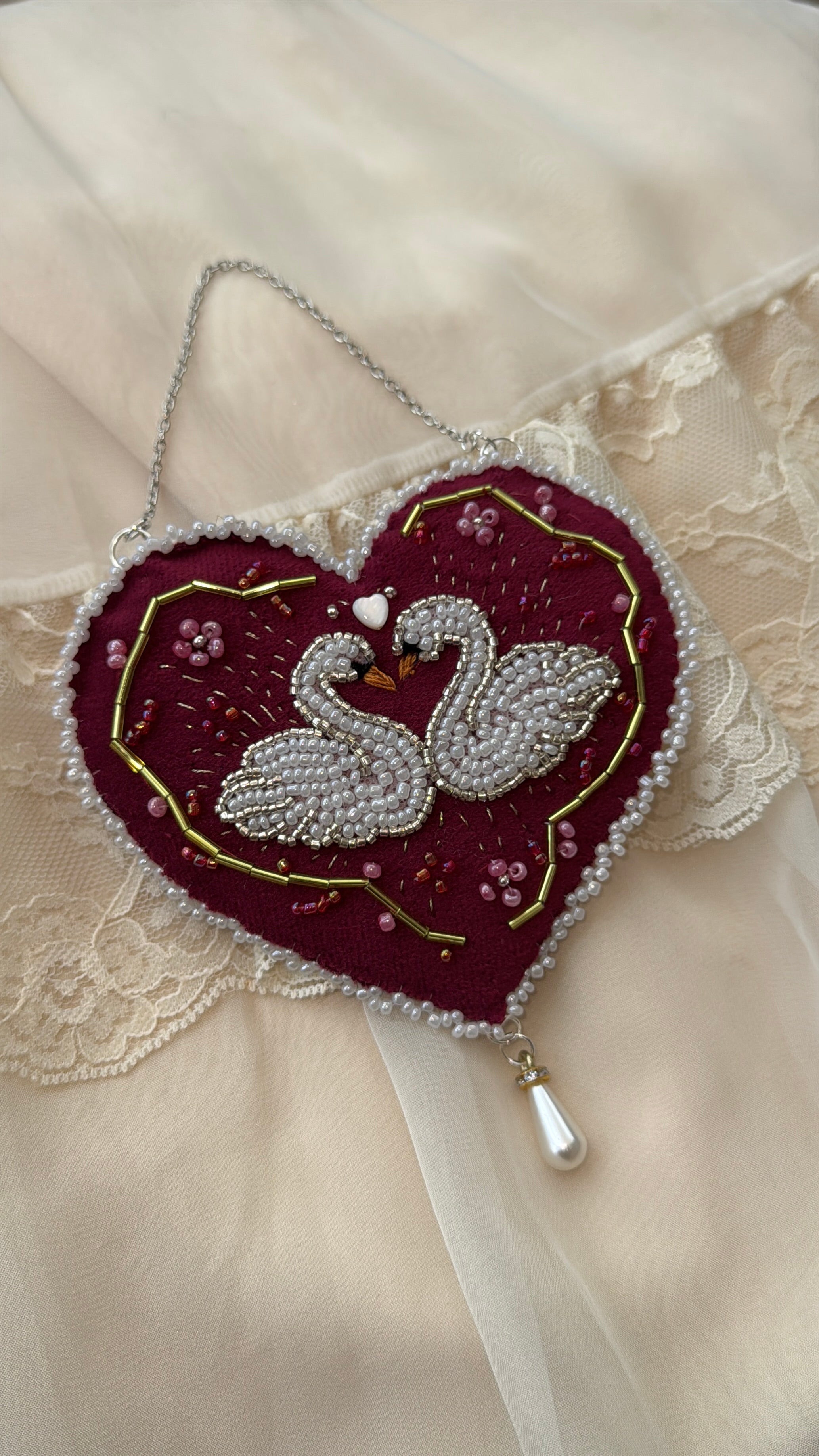 Decorative velvet wall hanging with twin swans and floral design on a lace background