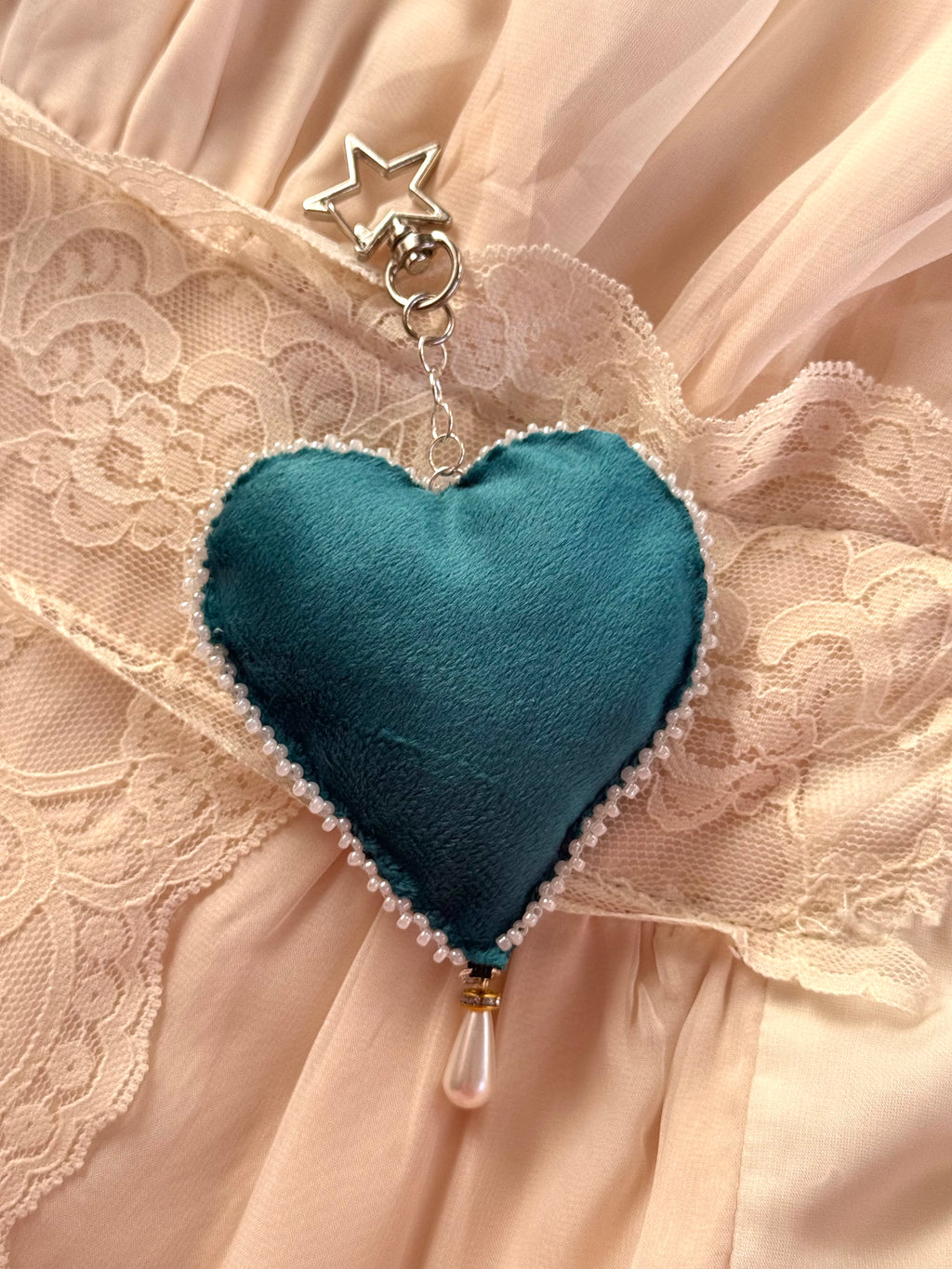 Blue heart-shaped pendant with a star on a lace fabric background