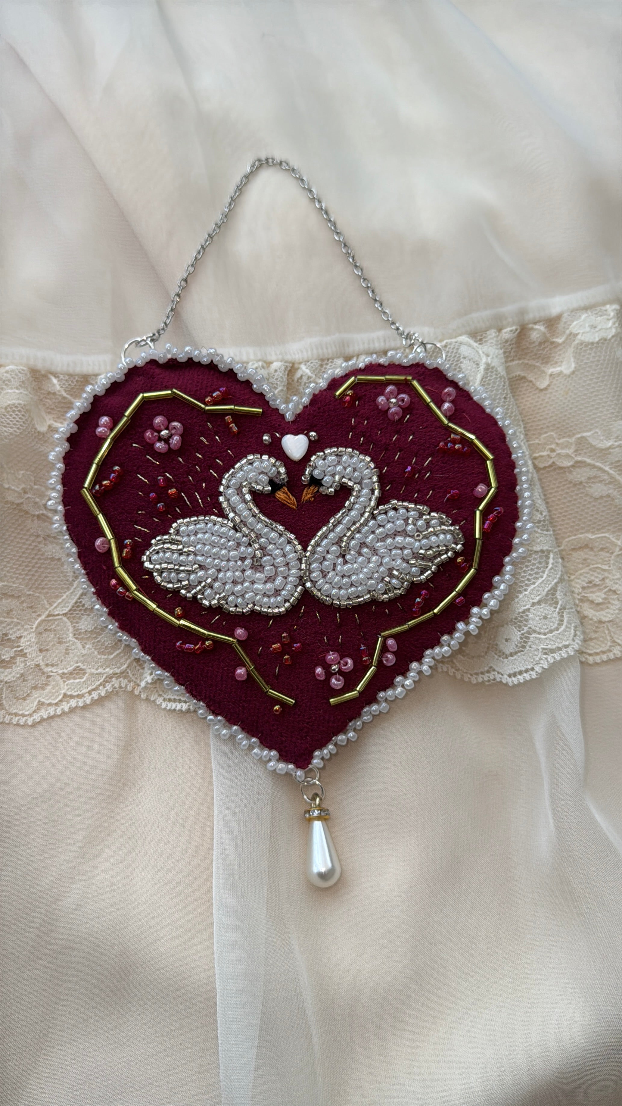 Decorative velvet wall hanging with twin swans and floral design on a lace background
