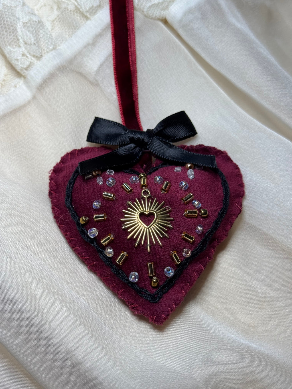 Decorative brooch with intricate design on a white fabric background