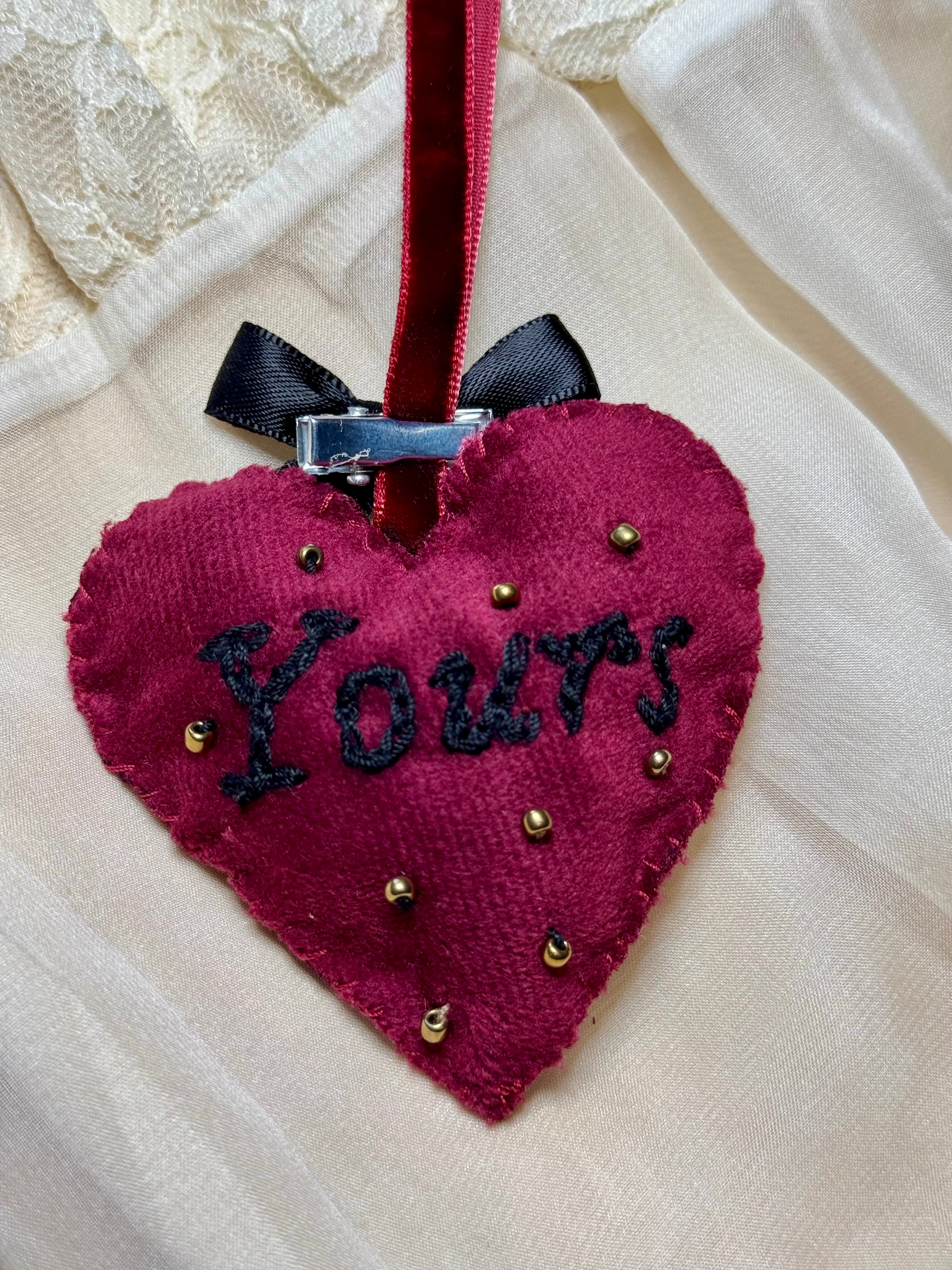 Heart-shaped fabric ornament with 'Yours' text on a white background