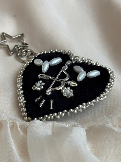 Heart-shaped pendant with decorative elements on a white fabric background