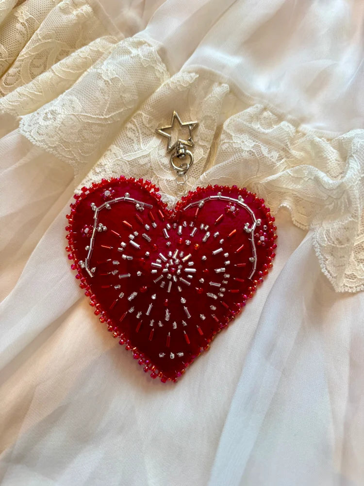Red heart-shaped embroidered patch on a white fabric background