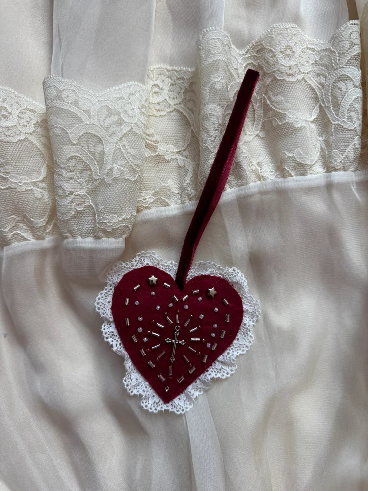 Heart-shaped embroidered object on a lace fabric background