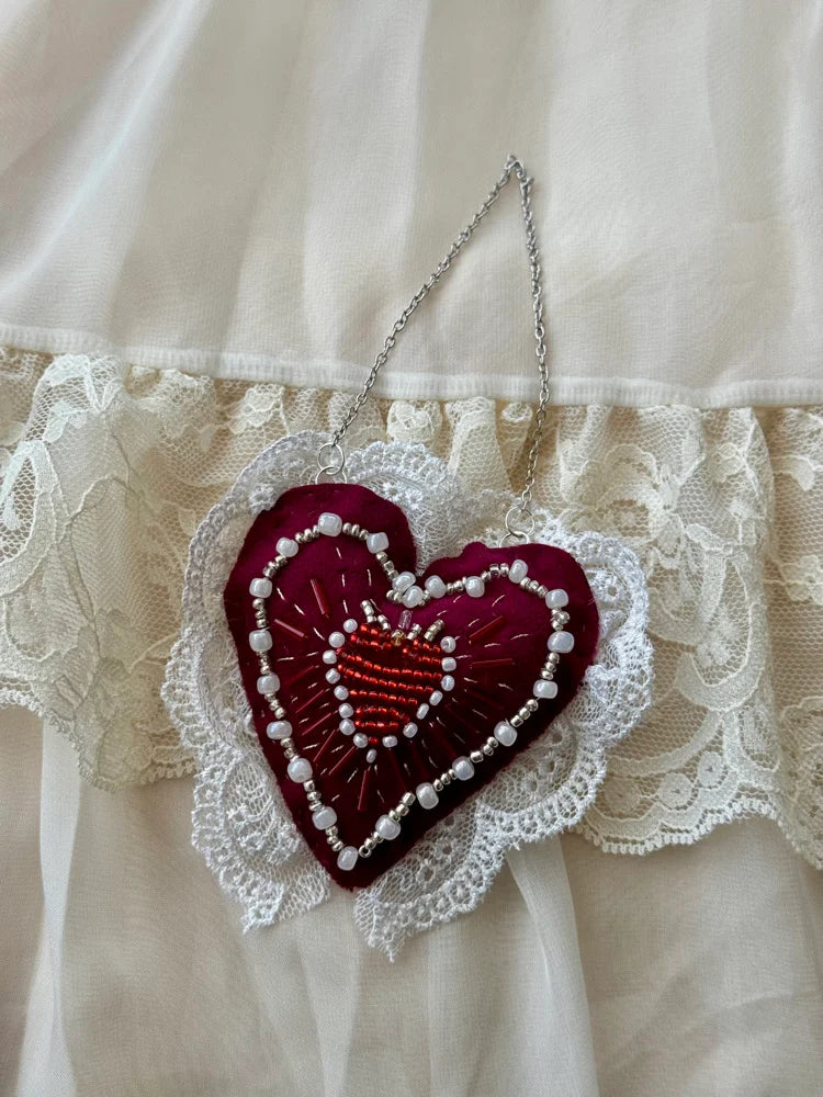 Embroidered heart decoration on a lace fabric background