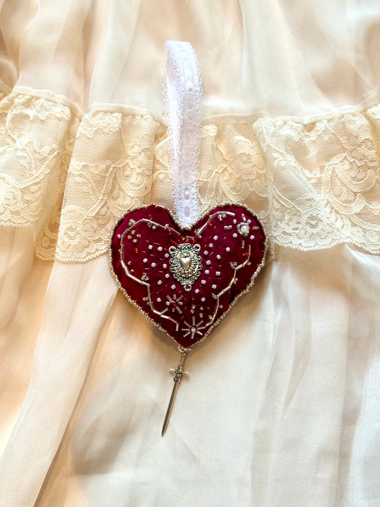Decorative heart-shaped brooch with lace background