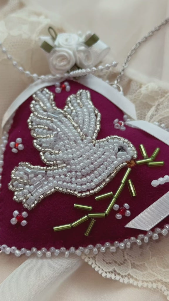 Heart-shaped pendant wall hanging with beaded dove design and satin roses on a lace background
