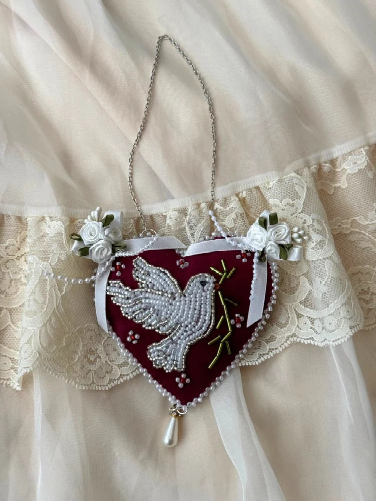 Heart-shaped pendant wall hanging with beaded dove design and satin roses on a lace background