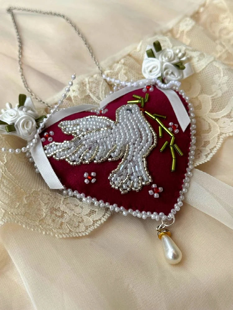 Heart-shaped pendant wall hanging with beaded dove design and satin roses on a lace background