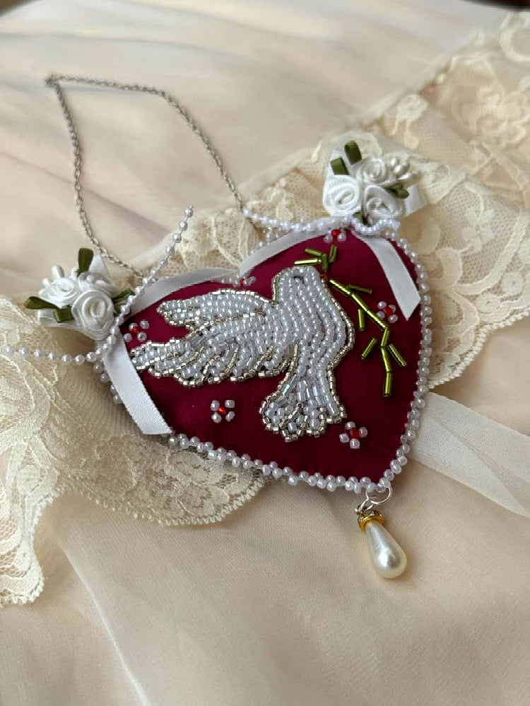 Heart-shaped pendant wall hanging with beaded dove design and satin roses on a lace background