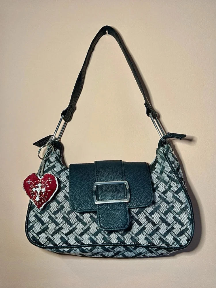 Patterned handbag with a heart-shaped charm on a beige background