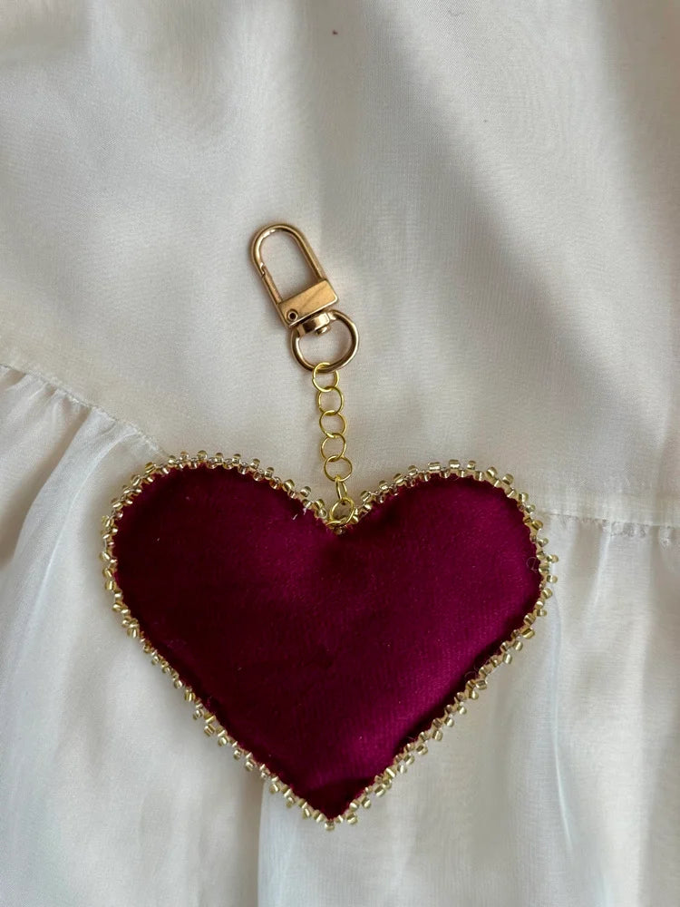Heart-shaped keychain with gold trim on a white background